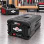 Briggs & Stratton 82V MAX 4Ah lithium battery on workbench with charger in background