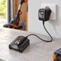 Chargeur de batterie WORX WA3760 20 V branché sur prise, posé sur un établi